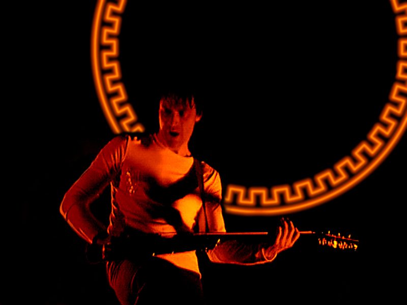 Guitarrista de The Sisters of Mercy iluminado en rojo durante un concierto