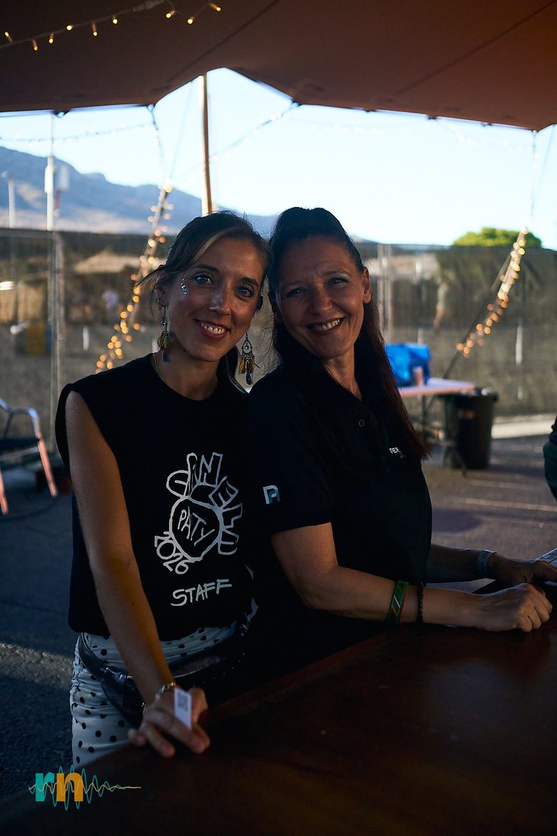 Two members of the Canela Party staff smiling at a bar