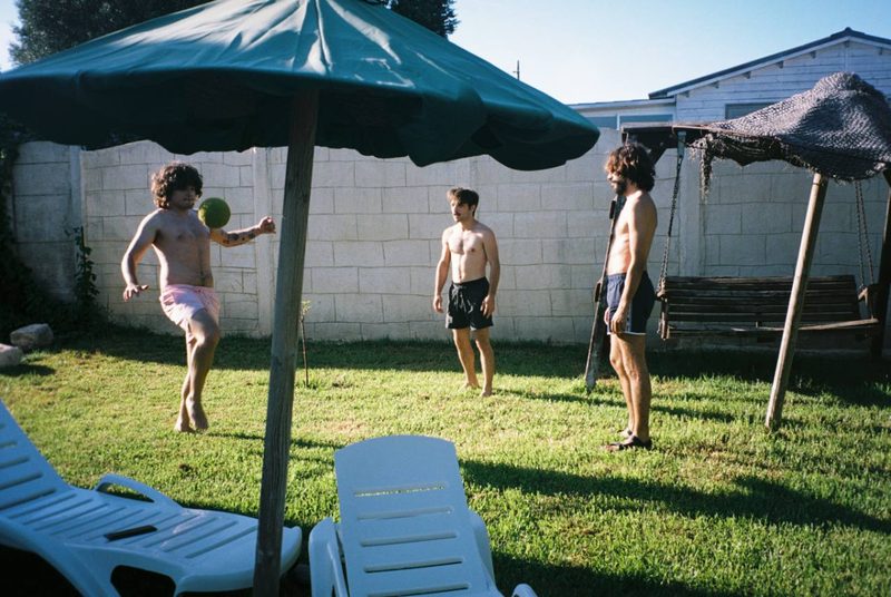 Tres integrantes de Construimos Escaleras jugando a la pelota en un jardín