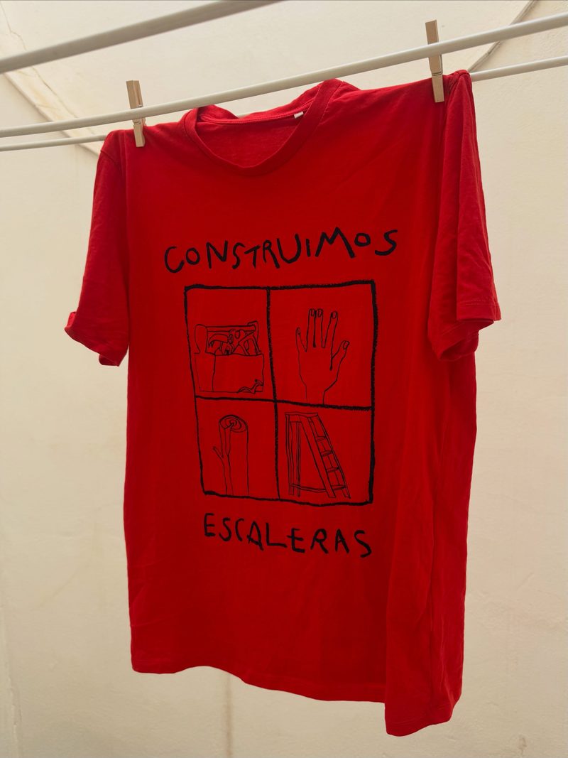 Red Construimos Escaleras T-shirt featuring the band's official illustration