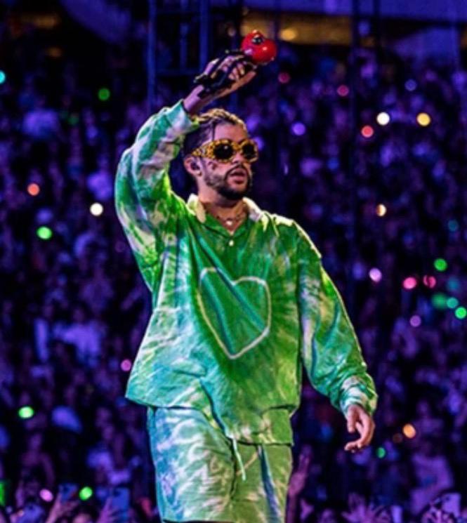 Artista urbano con traje verde en un macroconcierto.