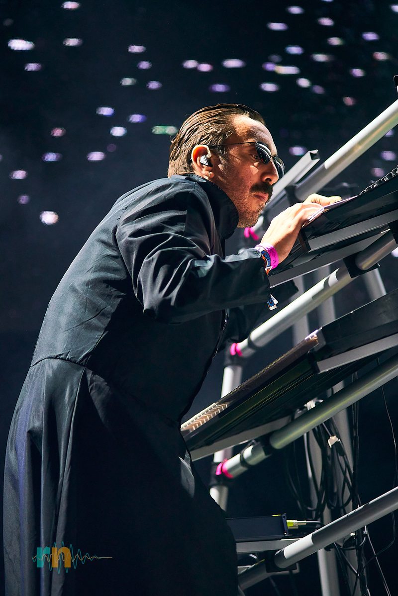 El teclista de Cervatana se inclina sobre su sintetizador bajo luces blancas y violetas en Canela Party 2026.