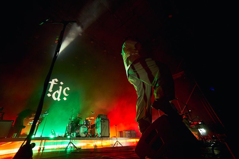 The Fontaines D.C. singer approaches the edge of the stage amid green and red light in Alicante, Spain.