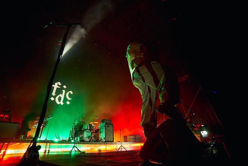 The Fontaines D.C. singer approaches the edge of the stage amid green and red light in Alicante, Spain.