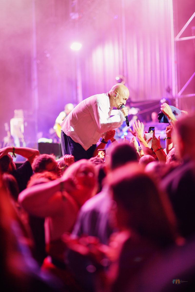 Tim Booth se acerca a las primeras filas durante el concierto