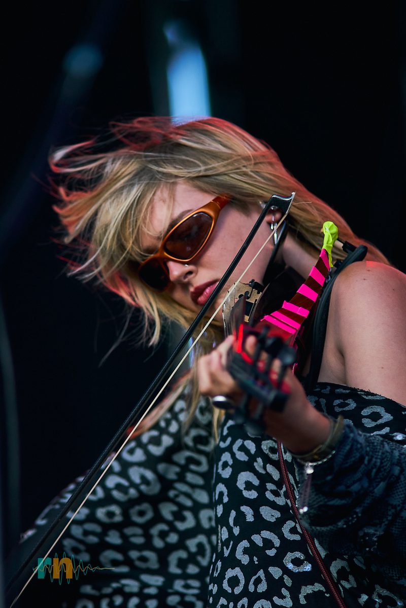 La violinista de Man/Woman/Chainsaw toca con el arco entre el cabello al viento durante Canela Party 2026.