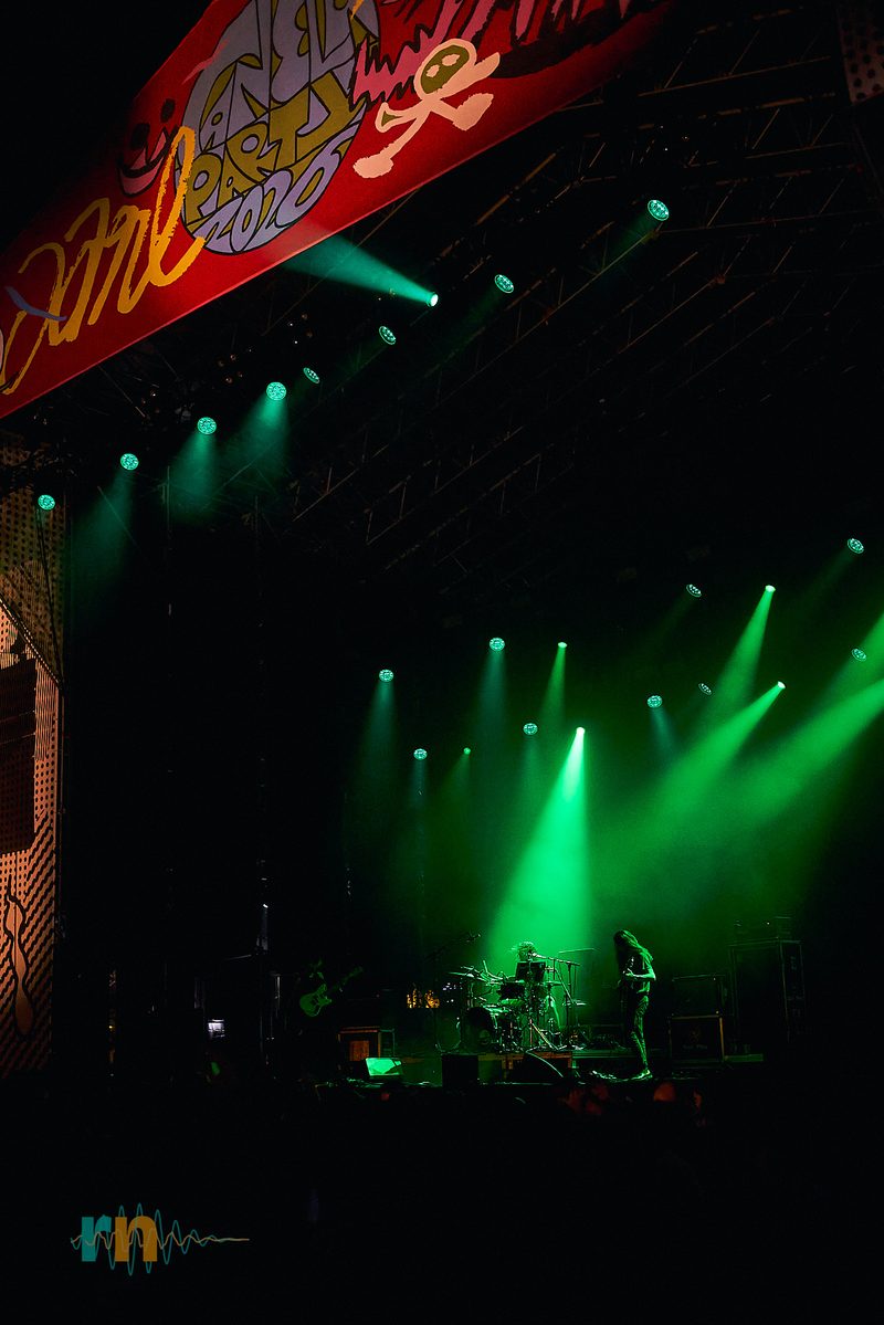 Wide view of MAQUINA. on the Canela Party 2026 stage beneath an array of green spotlights.